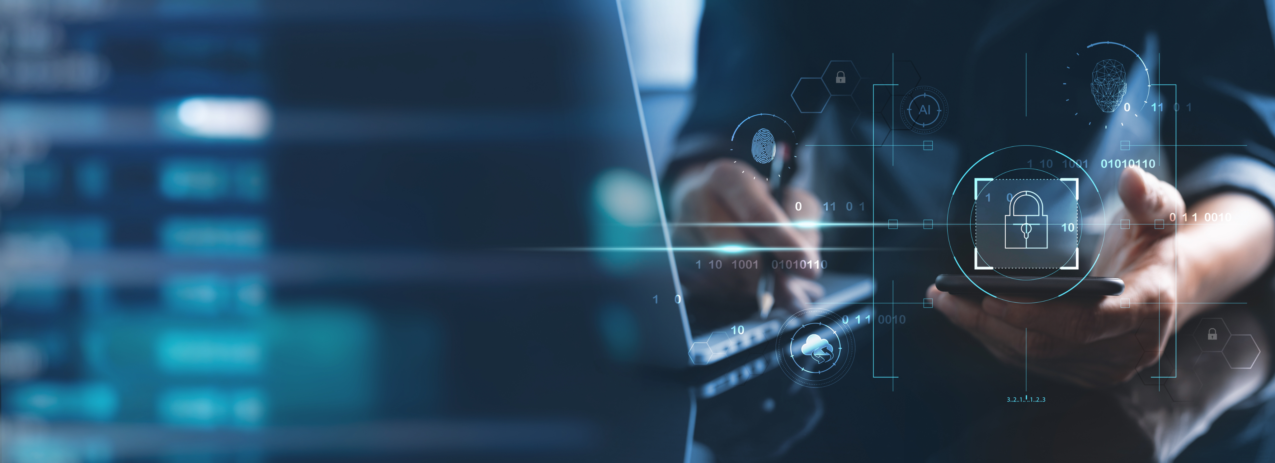 Person sitting on laptop holding a pen and phone